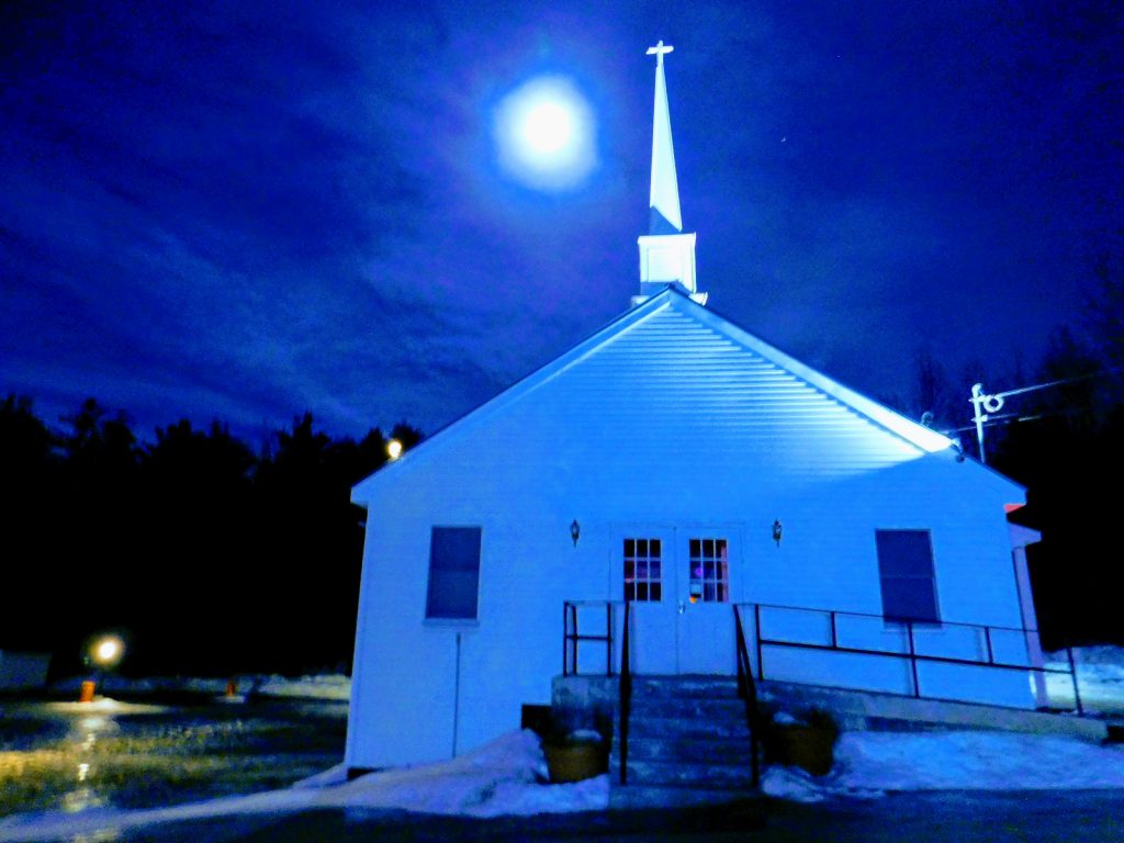 White church with a full and blue moon behind it. This blue moon was the inspiration for this article about my Multiple Sclerosis diagnosis. 