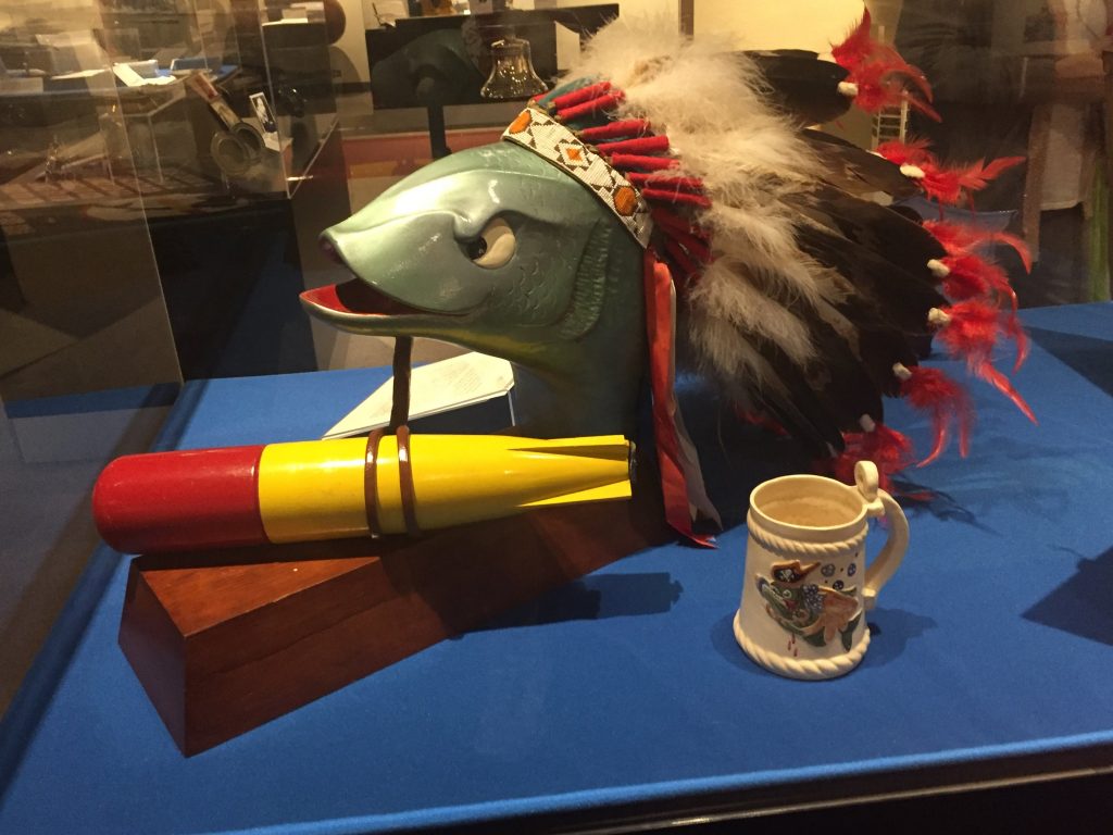 A fish head with an Indian head dress and a torpedo