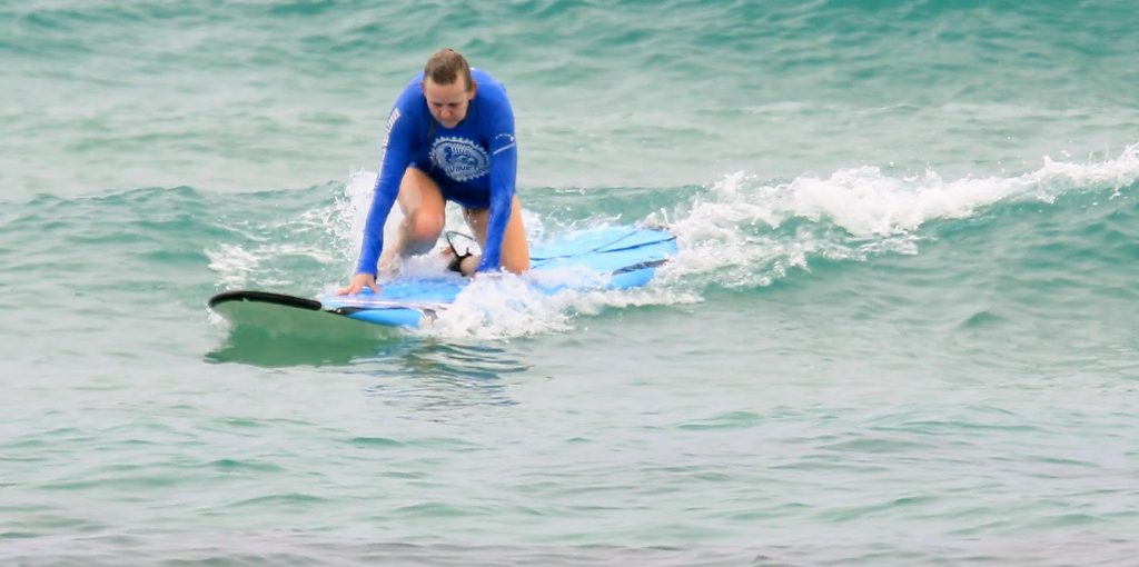 Karen almost getting up during her first surfing with MS trial