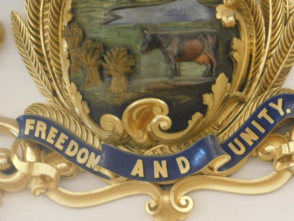 Vermont state seal, cow, wheat stalks and Freedom and Unity