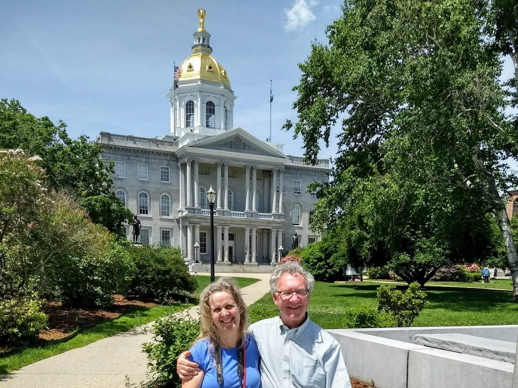 Tom and Karen at the NH state house where they started not one, but TWO travel quests.