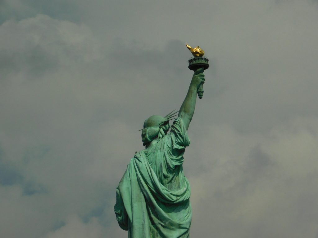 Lady Liberty holding up her torch against a stormy sky