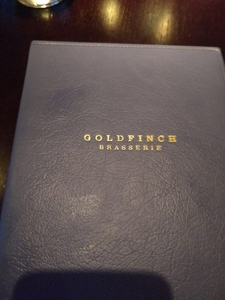 The menu book of The Goldfinch Brasserie in Waldorf Astoria Amsterdam where we found many pictures of The Goldfinch painting. 