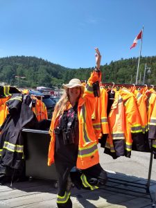 Karen in orange, black and yellow rain gear, ready to go see whether there are any whales to be found.