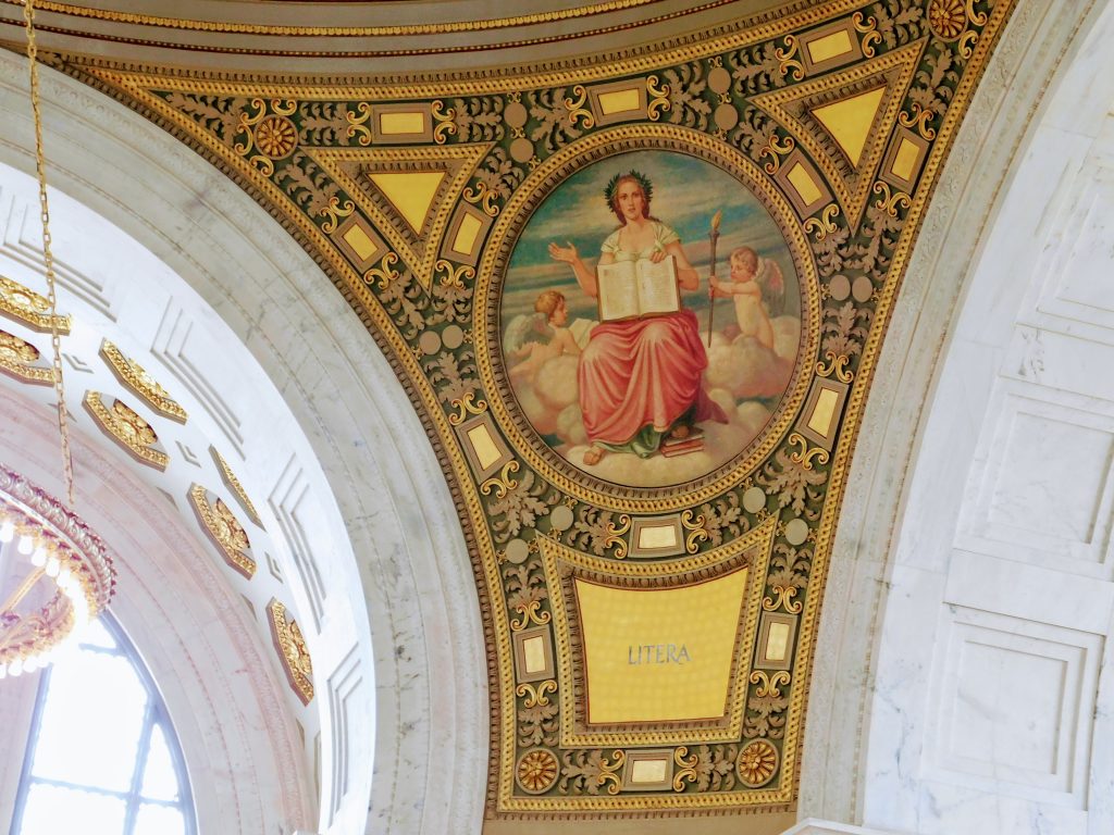 The personified value of literature, inside the rotunda of the Rhode Island State House. She is surrounded by two cherubs.