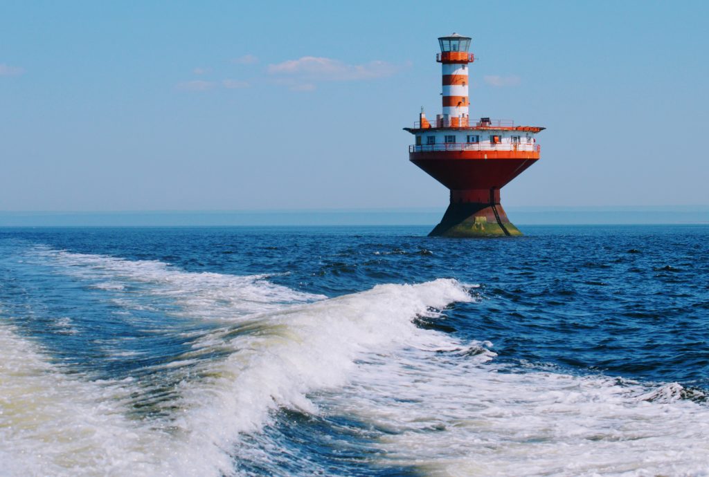 Orange and white light house surrounded by water. Haut-fond Prince (Prince Shoal) Lighthouse. Nowadays it is automated, but there used to be people working and living there.