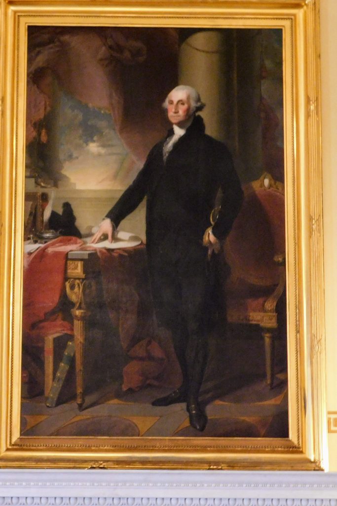 Portrait of George Washington, standing at a table, painted by Gilbert Stuart