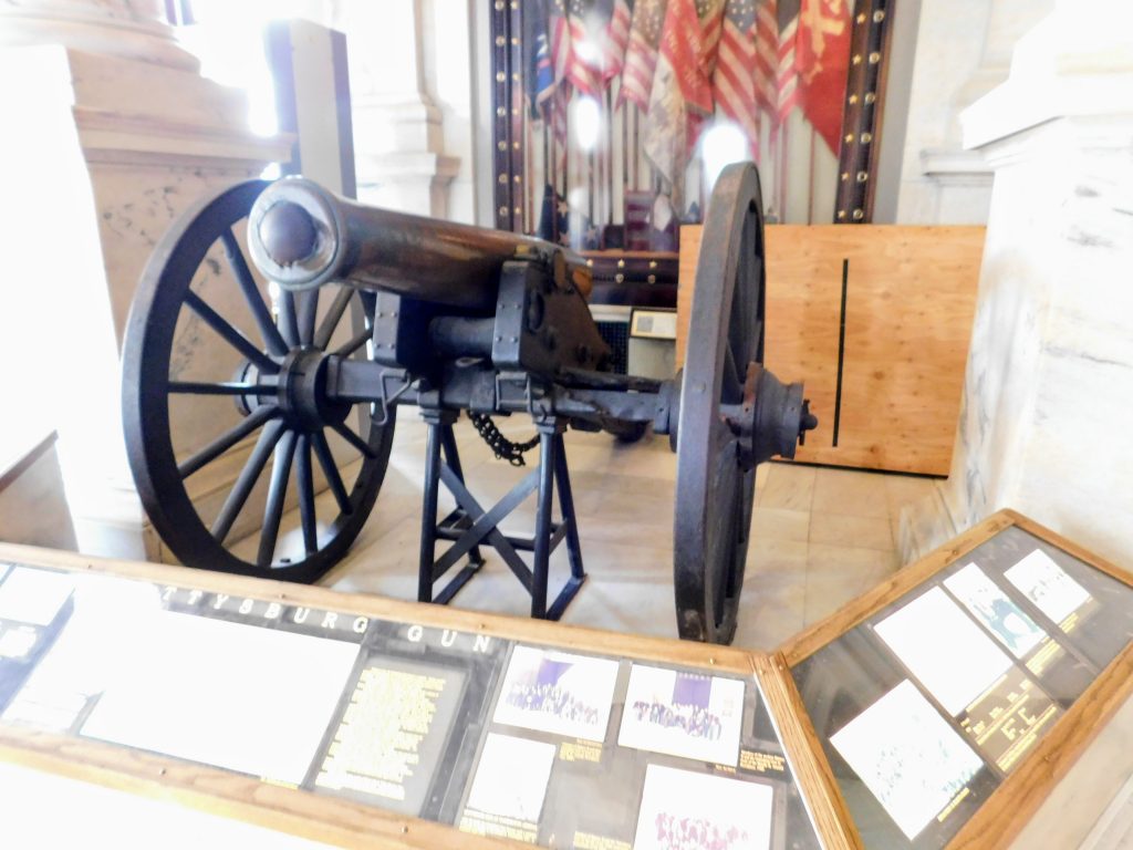 Gun with cannon ball stuck in muzzle. In the background you can see some of the battle flags. 