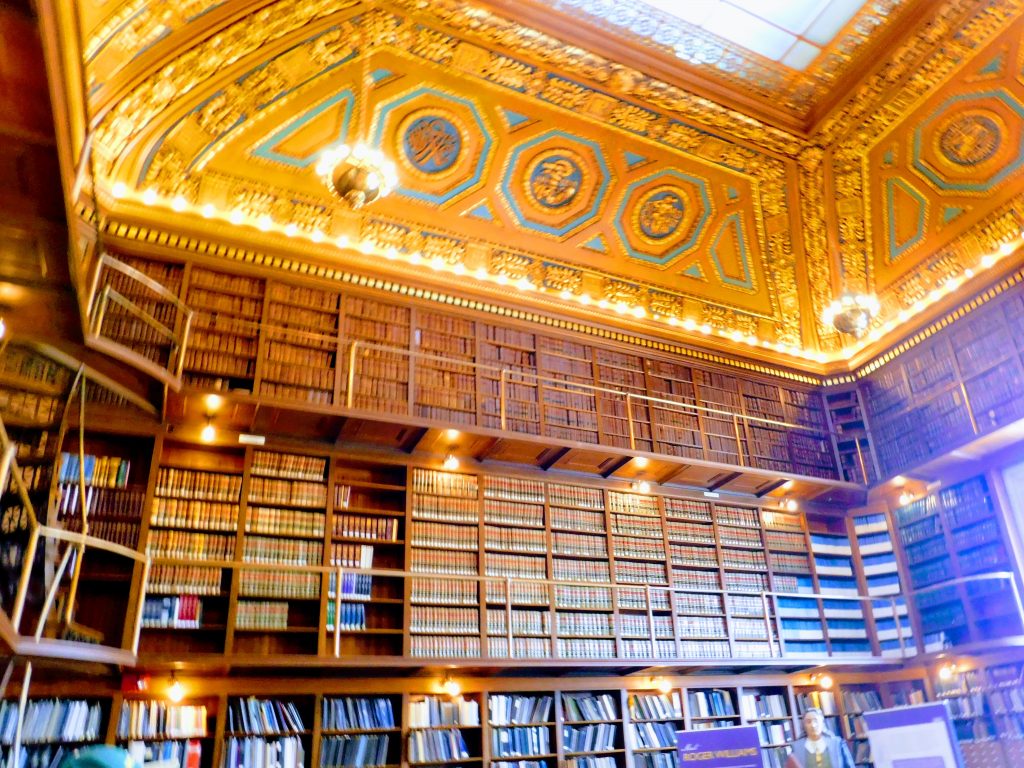 Three tiers of books and a very elaborately decorated ceiling