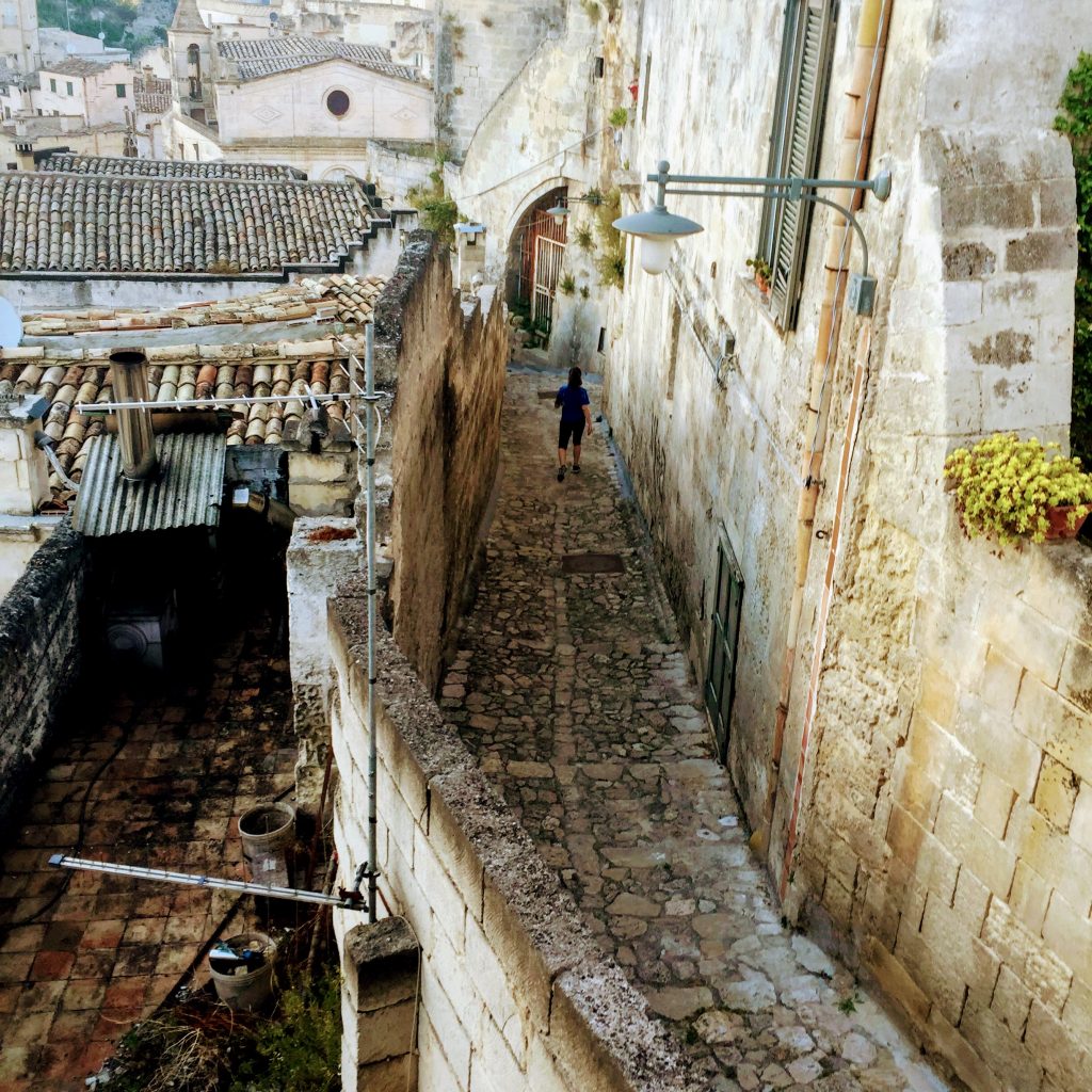 Looking down on a person walking down a staircase in Matera.