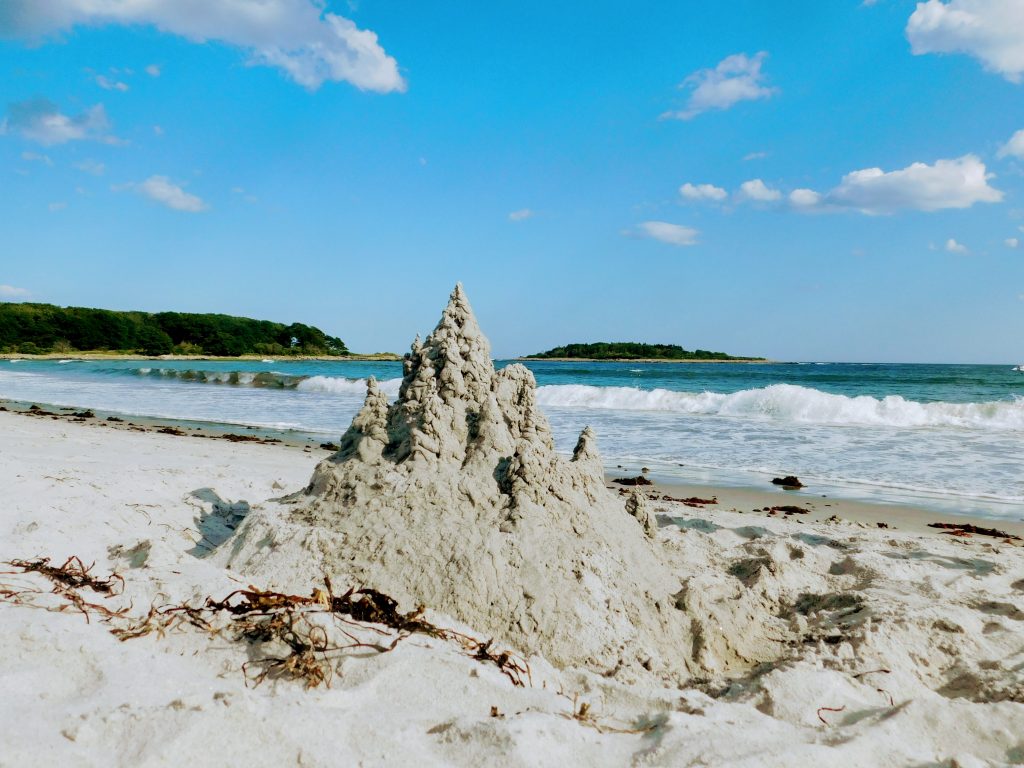 Sand castle on Goose Rocks Beach in Kennebunkport overlooking the water and Timber Island in the distance 