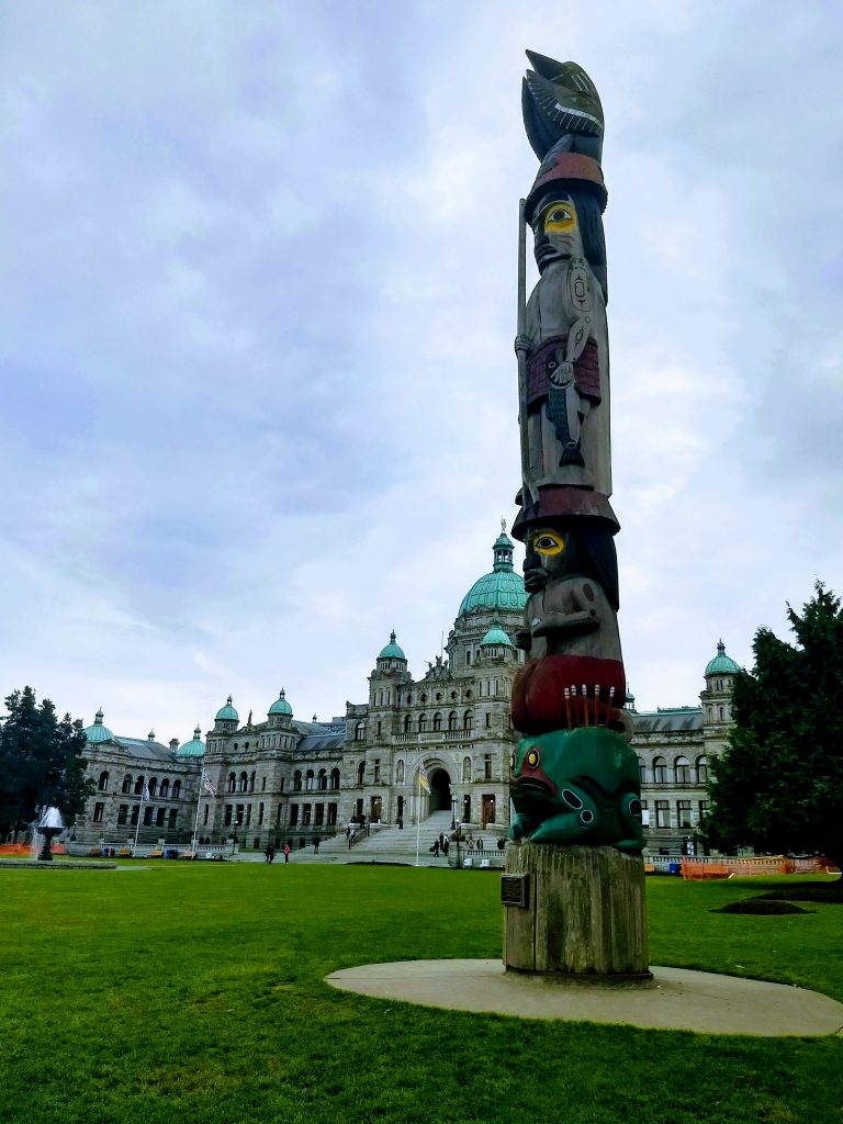 Totem pole in front of British Columbia Parliament Building
