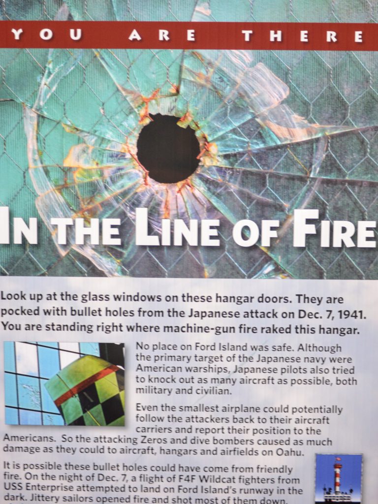 YOU ARE THERE
IN THE LINE OF FIRE
Look up at the glass windows on these hangar doors. They are pocked with bullet holes from the Japanese attack on Dec. 7, 1941. You are standing right where machine-gun fire raked this hangar.
No place on Ford Island was safe. Although the primary target of the Japanese navy were American warships, Japanese pilots also tried to knock out as many aircraft as possible, both military and civilian.
Even the smallest airplane could potentially follow the attackers back to their aircraft carriers and report their position to the Americans. So the attacking Zeros and dive bombers caused as much damage as they could to aircraft, hangars and airfields on Oahu.
It is possible these bullet holes could have come from friendly fire. On the night of Dec. 7, a flight of F4F Wildcat fighters from USS Enterprise attempted to land on Ford Island's runway in the dark. Jittery sailors opened fire and shot most of them down, in this direction. Only one Wildcat
OPERATIONS NAS