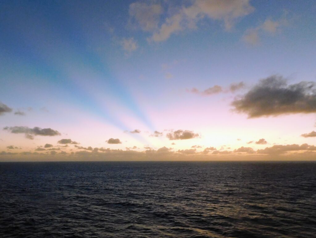 Ocean with colorful sunset and clouds. Free sunsets for transatlantic cruises!