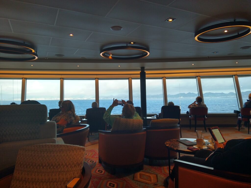 People in lounge watching the Azores but never getting there on this transatlantic cruise