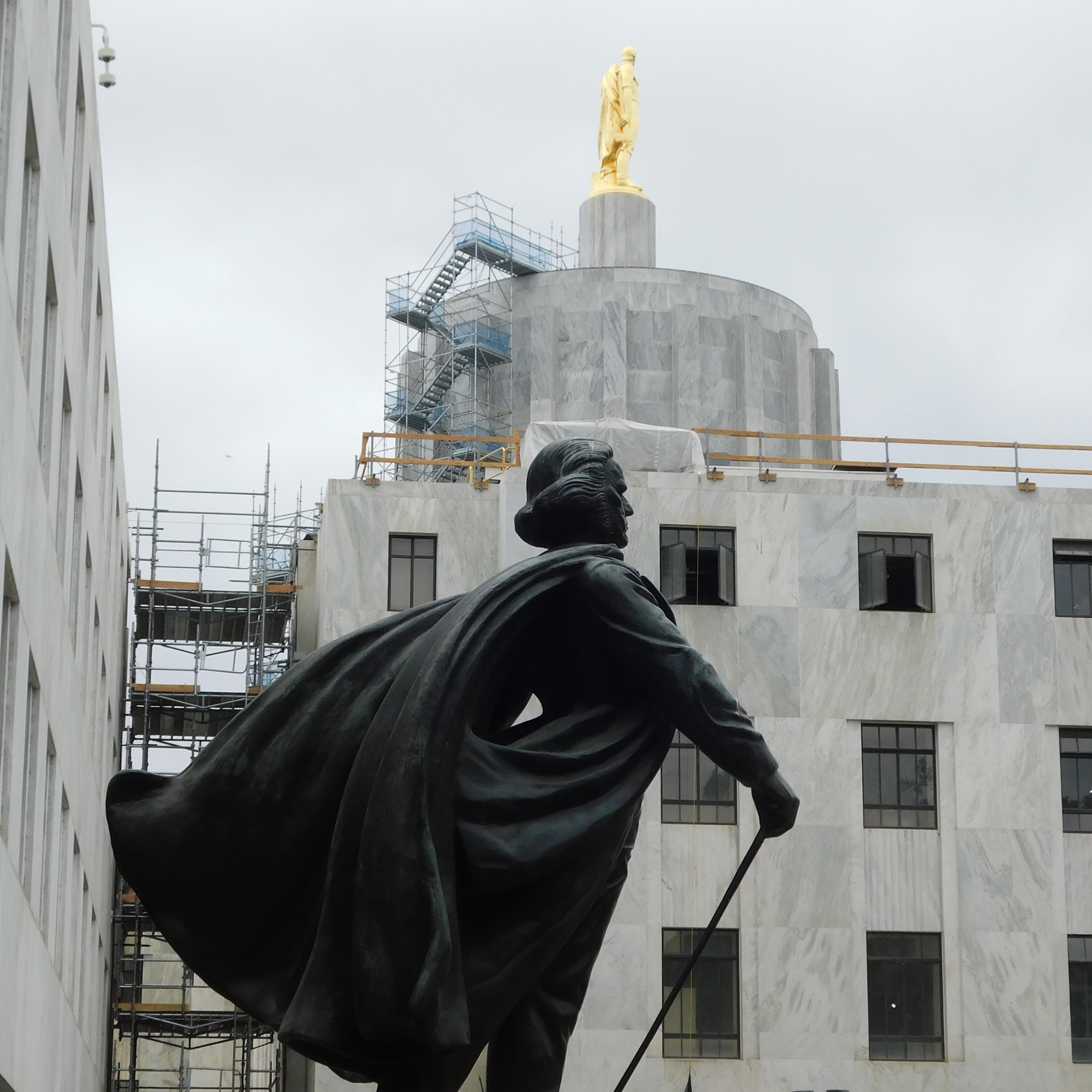 Showing a brisk walking guy statue in front of the Oregon State Capitol